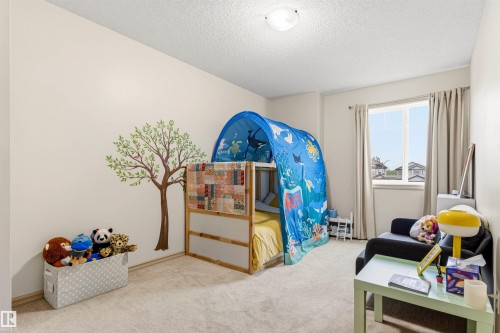 Neutral wall paint, plush carpet flooring, a window with drapery, and a simple ceiling light fixture - 14807 141 Street, Edmonton, AB 