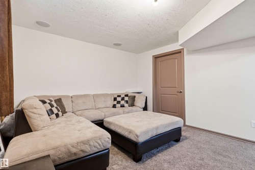 Carpeted interior space featuring white walls and a warm brown six-panel door - 14807 141 Street, Edmonton, AB 