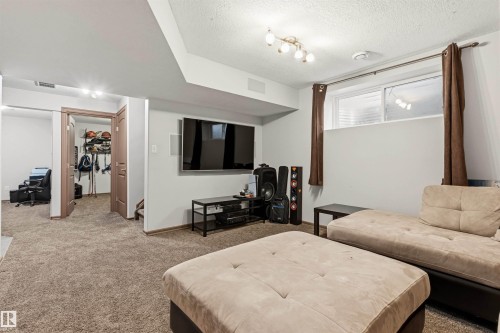 Carpeted recreation room featuring white walls and a drop ceiling - 14807 141 Street, Edmonton, AB 