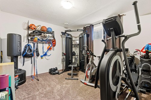 Carpeted room featuring a ceiling-mounted light fixture and a single window with blinds - 14807 141 Street, Edmonton, AB 