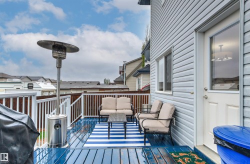 Outdoor deck with blue wood-finish flooring, white railing, and grey exterior siding - 14807 141 Street, Edmonton, AB 