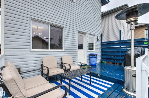 Blue-stained wood deck featuring horizontal blue fencing and white exterior siding - 14807 141 Street, Edmonton, AB 