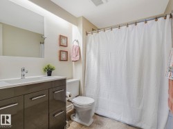 Bathroom featuring a modern vanity with a rectangular sink, chrome faucet, wall-mounted mirror, and a full bathtub with a shower rod - 