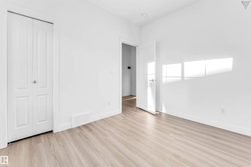 Bright room featuring light wood-finish flooring, white baseboards, and clean white walls - 1224 14 Avenue Nw, Edmonton, AB - Indoor Photo Showing Other Room