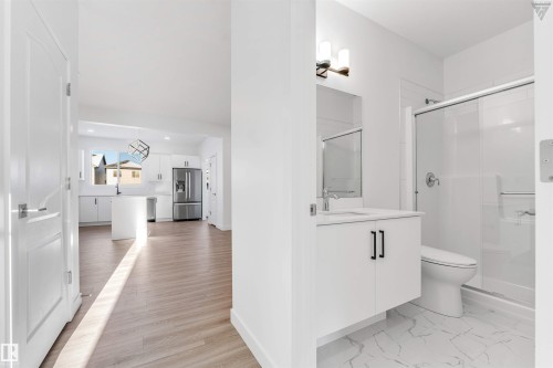 Contemporary bathroom featuring a floating vanity with a white countertop, chrome faucet, and a large mirror - 1224 14 Avenue Nw, Edmonton, AB - Indoor Photo Showing Bathroom