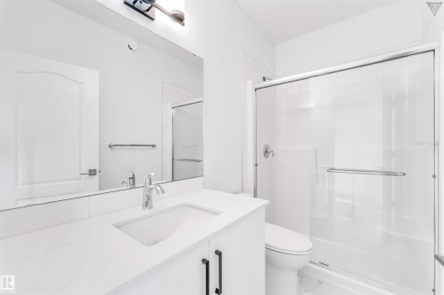 Bathroom featuring a white vanity with an integrated sink, polished chrome faucet, and black cabinet pulls - 1224 14 Avenue Nw, Edmonton, AB - Indoor Photo Showing Bathroom