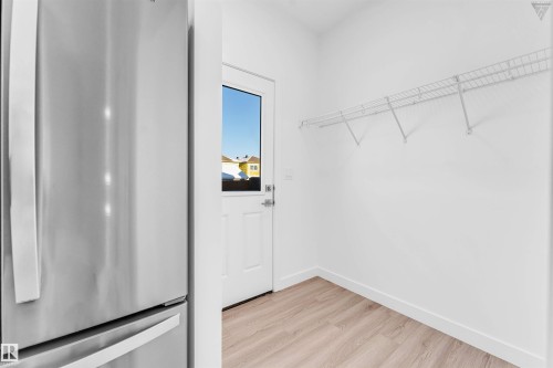 Utility space featuring light wood-finish flooring, white walls, and a white wired shelving system - 1224 14 Avenue Nw, Edmonton, AB - Indoor