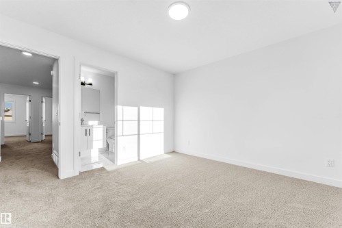 Room featuring neutral-toned carpeting, white walls, and a flush-mount ceiling light - 1224 14 Avenue Nw, Edmonton, AB - Indoor Photo Showing Other Room