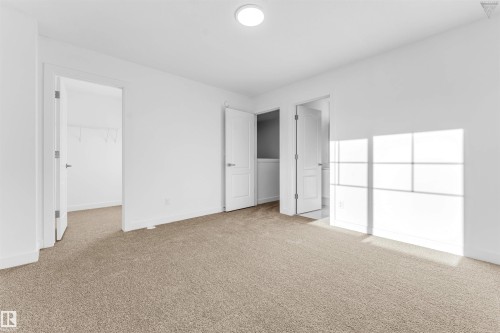 Spacious room featuring neutral carpeting, white walls, and a flush-mount ceiling light - 1224 14 Avenue Nw, Edmonton, AB - Indoor Photo Showing Other Room