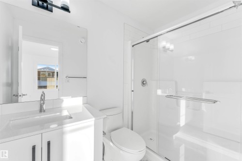 Bathroom featuring a white vanity with integrated sink, chrome faucet, and quartz countertop - 1224 14 Avenue Nw, Edmonton, AB - Indoor Photo Showing Bathroom