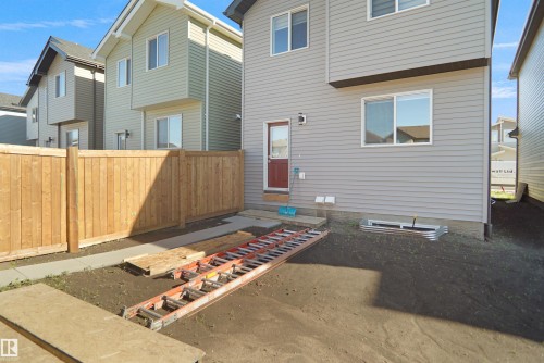 Rear exterior featuring light gray horizontal siding and white-framed windows - 1224 14 Avenue Nw, Edmonton, AB - Outdoor With Exterior