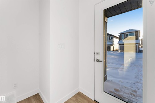 Entryway featuring a full-light door with clear glass, wood-finish flooring, white baseboards, and a white wall finish - 1224 14 Avenue Nw, Edmonton, AB - Indoor Photo Showing Other Room