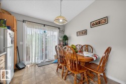 Tiled flooring in a dining area featuring a sliding glass door, a semi-flush mount light fixture, and light gray wall paint - 