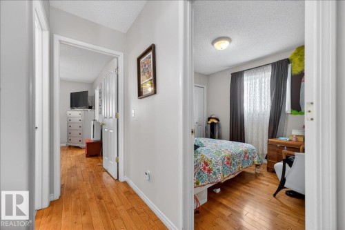 Hallway featuring wood-finish flooring and light gray wall paint - 5108 138A Avenue, Edmonton, AB 
