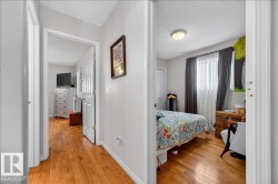 Hallway featuring wood-finish flooring and light gray wall paint - 
