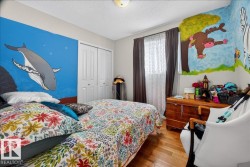 Bedroom featuring wood-finish flooring, a double-door closet, and a ceiling-mounted light fixture - 