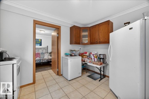 Kitchen featuring wood cabinetry, overhead lighting, and tile flooring - 5108 138A Avenue, Edmonton, AB 