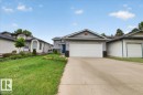 Exterior featuring a concrete driveway, attached garage with a white door, and textured stucco siding - 5108 138A Avenue, Edmonton, AB 