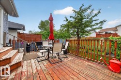 Elevated wood deck featuring stairs and a solid wood railing - 