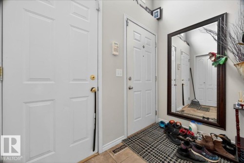 Foyer featuring two paneled doors, a full-length framed mirror, and light-toned wall paint - 5108 138A Avenue, Edmonton, AB 