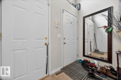 Foyer featuring two paneled doors, a full-length framed mirror, and light-toned wall paint - 