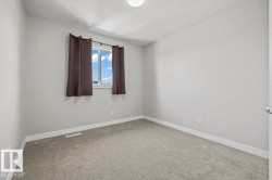 Neutral gray wall finish, plush gray carpeting, white trim, and a window with brown drapes - 