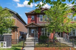 Two-story residence featuring red siding and dark trim accents - 