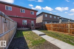 Red siding exterior with multiple windows, a rear deck, and a privacy fence - 