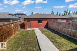 Detached garage featuring red siding, a brown entry door, and multiple windows - 