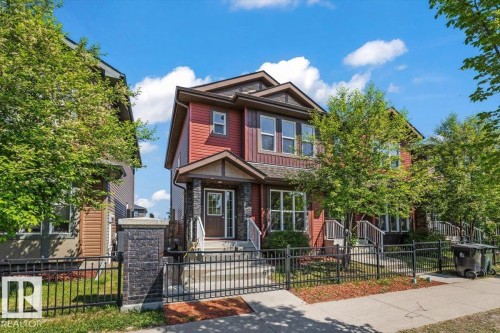 Two-story residence featuring red siding and dark stone facade accents - 356 Pioneer Road, Spruce Grove, AB 