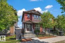Two-story residence featuring red siding and dark stone facade accents - 356 Pioneer Road, Spruce Grove, AB 