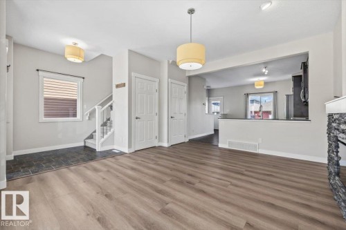 Spacious main living area featuring wood-finish flooring and a stone-clad fireplace - 356 Pioneer Road, Spruce Grove, AB 