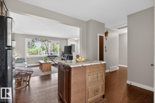 Kitchen island featuring a stone-finish countertop and wood cabinetry - 9815 68 Avenue, Edmonton, AB - Indoor
