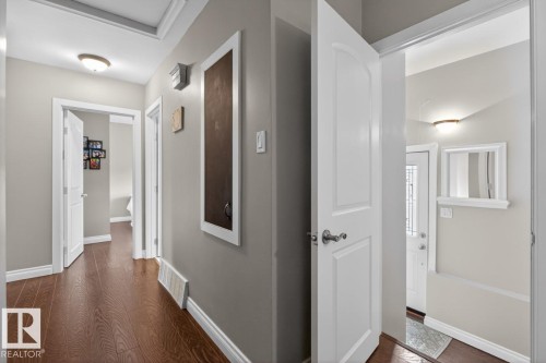 Hallway with wood-finish flooring, white trim, and neutral wall paint - 9815 68 Avenue, Edmonton, AB - Indoor Photo Showing Other Room