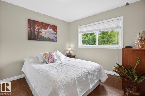 Bedroom featuring wood-finish flooring, neutral wall paint, and white baseboards - 9815 68 Avenue, Edmonton, AB - Indoor Photo Showing Bedroom