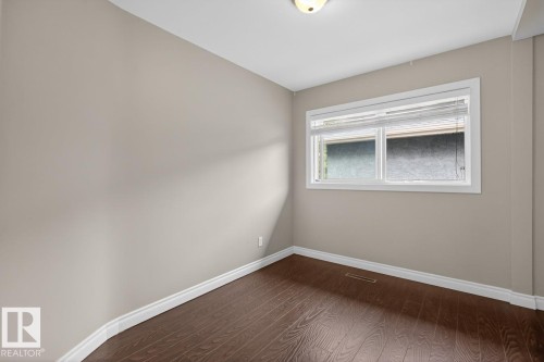 Neutral-toned walls complement wood-finish flooring - 9815 68 Avenue, Edmonton, AB - Indoor Photo Showing Other Room