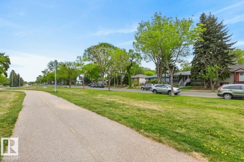 Paved pathway bordered by extensive green space with mature trees - 9815 68 Avenue, Edmonton, AB - Outdoor