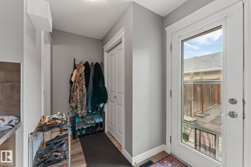 Entryway featuring a full-light exterior door, wood-finish flooring, and light gray wall paint - 5813 63 Street, Beaumont, AB 