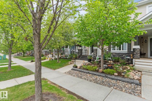 Exterior with cream siding, dark stone accent details, and white trim - 5813 63 Street, Beaumont, AB 