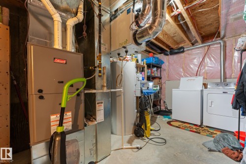 Dedicated utility space featuring a furnace, water heater, and side-by-side washer and dryer - 5813 63 Street, Beaumont, AB 