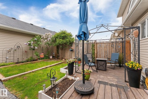 Wood-finish deck with a metal gazebo structure, string lighting, and privacy fencing - 5813 63 Street, Beaumont, AB 