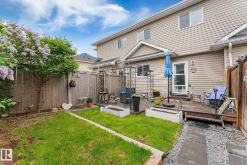 Backyard featuring a wooden privacy fence, a wood deck with steps, and a grass lawn - 5813 63 Street, Beaumont, AB 