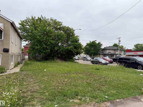 Expansive grass lot featuring mature trees and a paved sidewalk - 10737 95 Street, Edmonton, AB 