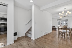 Open-concept living space featuring wood-finish flooring - 