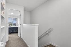 Carpeted hallway with built-in shelving and white painted walls - 