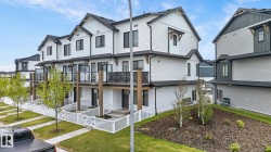 Modern townhome exteriors featuring white horizontal siding and dark trim - 