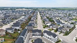 Expansive residential community featuring a variety of detached homes and multi-story townhomes, each with dark-toned roofs - 