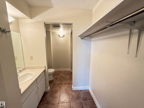 Bathroom featuring a single-basin vanity with a light-colored countertop and a mirror - 706 10125 109 Street, Edmonton, AB 