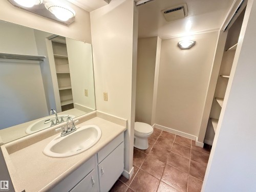 Bathroom featuring a vanity with an integrated sink, polished chrome faucet, and expansive mirror - 706 10125 109 Street, Edmonton, AB 