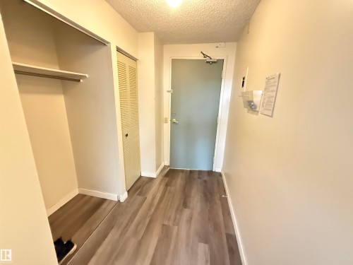 Entryway featuring wood-finish flooring, white baseboards, and a recessed ceiling light - 706 10125 109 Street, Edmonton, AB 